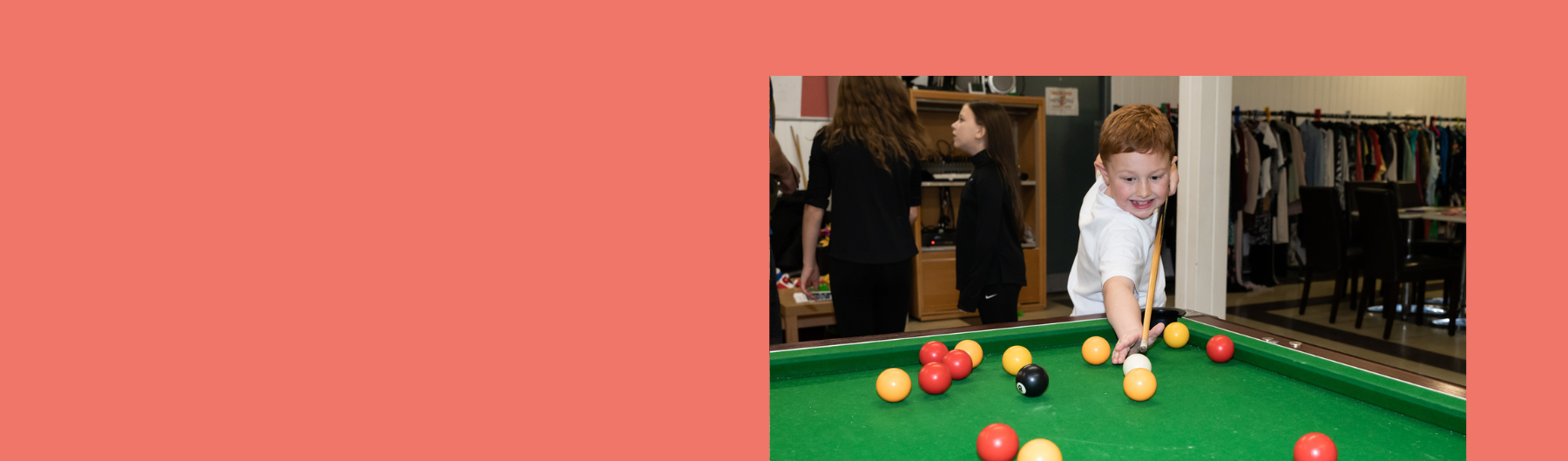 photo of a young boy playing snooker