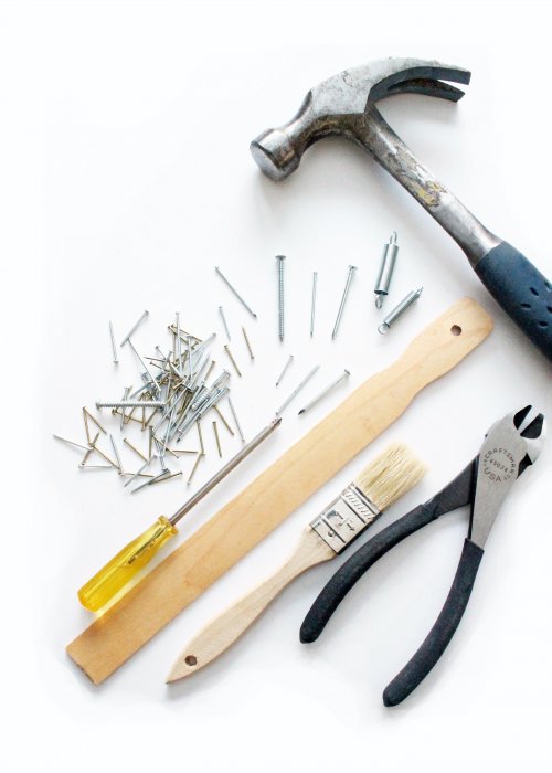 Various tools and paintbrushes on a white surface