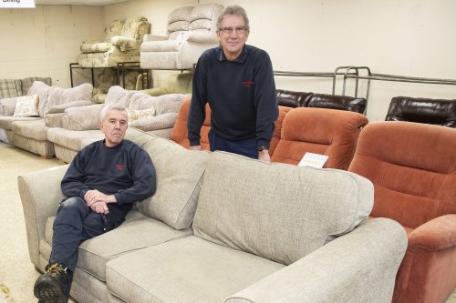 Foundations staff sitting on donated sofas in their charity showroom