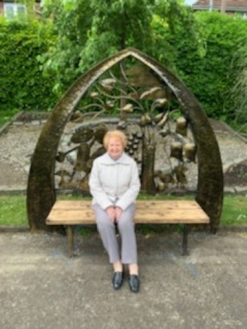 a photo of a women seating on the friendship bench
