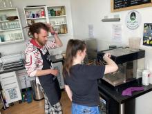 Two people in the kitchen using a barista coffee machine