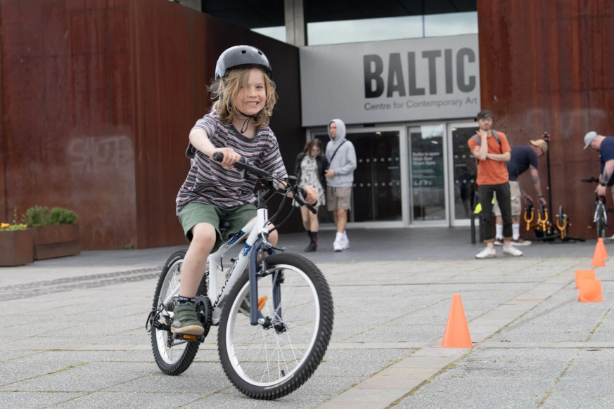 A child is riding a bike and smiling