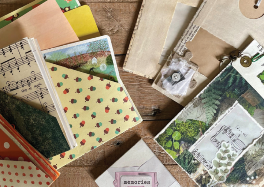 A photo of two memento books made out of different papers. One book on the left is made out of acorn-patterned paper and sheet music, whilst the book on the right is made out of photos of plants.