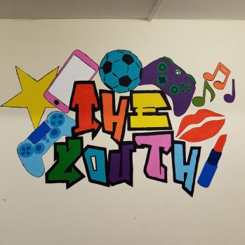 A mural designed by young people stating "the youth" surrounded by makeup, sports equipment and games consoles