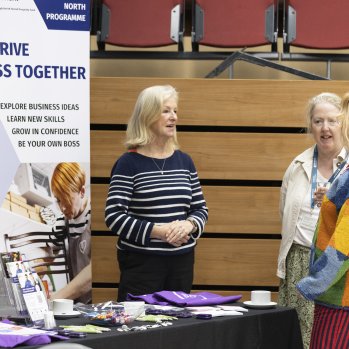 A photo of four people having a conversation at a business support booth.