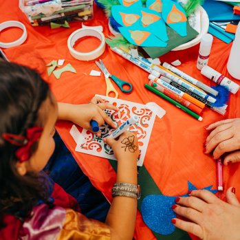 A child drawing on a patterned stencil.