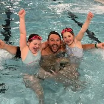a father and 2 children having fun in the swimming pool