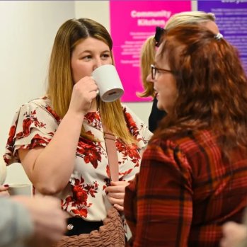 people talking whilst enjoying a mug of tea/coffee 