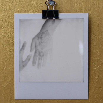 A black and white polaroid photo of a hand