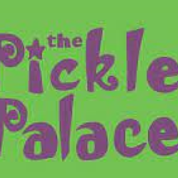 Green background Purple writing saying The Pickle Palace flanked by purple castle either side.