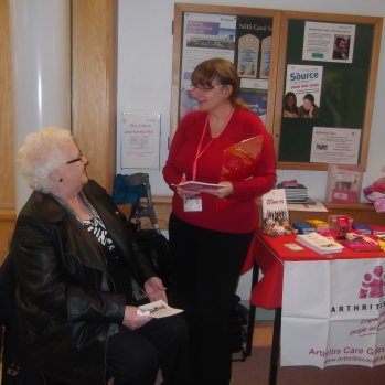 Volunteer helping an elderly woman at a drop in point