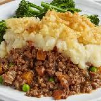 White plate of delicious looking shepherd's pie with green broccoli.