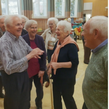 a group of older people chatting and laughing 