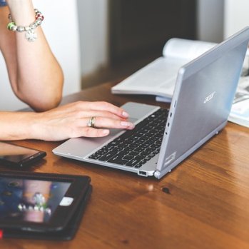 a womans hand on a laptop keyboard